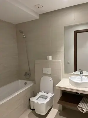 a white bathroom with a toilet and a sink at Appartement Steps from Anfa Park Fanzone in Casablanca
