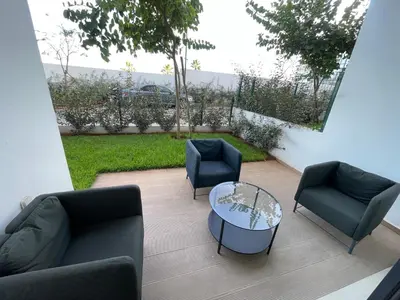 a patio with couches and a table and chairs at Appartement Steps from Anfa Park Fanzone in Casablanca