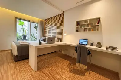 a bedroom with a bed and a desk with a laptop at Maya Suites - Cozy Flat with Terrace & Garden in Casablanca