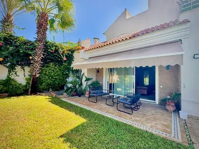 a house with a patio with chairs and a yard at Luxurious Ocean View Villa Ain Diab in Casablanca