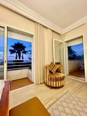 a living room with a chair and a large window at Luxurious Ocean View Villa Ain Diab in Casablanca