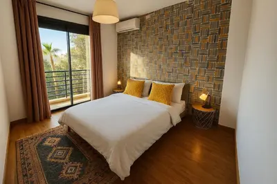 a bedroom with a bed with yellow pillows and a window at Cosy-Piscine-Parking in Casablanca