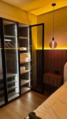 a bedroom with a walk in closet with a glass door at studio luxe rooftop & gym quartier des princess in Casablanca