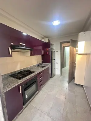 a large kitchen with purple cabinets and a stove at Marbella beach residency in Mansouria