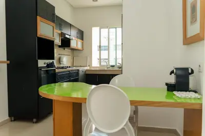 a kitchen with a green table and white chairs at Upper floor of a villa, Modern and bright in Rabat