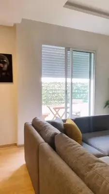a living room with a couch and a large window at Studio de standing à maarif in Maarif