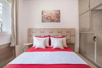 a bedroom with a large bed with red and white pillows at Sophia Atlantis Pool Patio Garage in Mohammedia