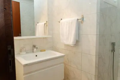 a white bathroom with a sink and a shower at Large 2 bedroom apartment in prime location - 2 Balconies & private Parking in Rabat