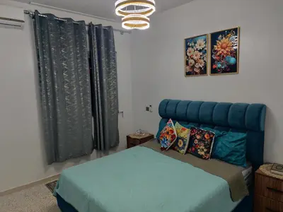 a bedroom with a bed with a blue headboard at Appartement a Oulad Mtaa ,Prés du stade Moulay Abdallah,Rabat in Rabat