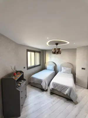 a bedroom with two beds and a chandelier at Luxueuse appartement centre ville TGV in Casablanca
