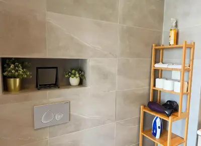 a bathroom with a tiled wall with a fireplace at Maya Suites - B LIVING CFC in Casablanca