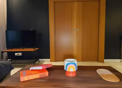 a living room with a wooden table with a game system on it at Maya Suites - B LIVING CFC in Casablanca