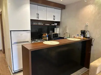 a kitchen with a counter and a refrigerator at Studio Calme, Cosy & Équipé, Plein Centre Agdal in Rabat