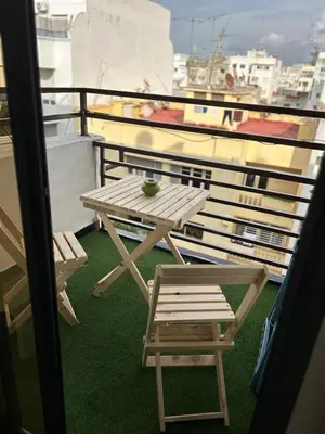 a picnic table and a chair on a balcony at Studio Calme, Cosy & Équipé, Plein Centre Agdal in Rabat