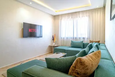 a living room with a couch and a tv at Appartement luxueux &chaleureux Agdal rabat in Rabat