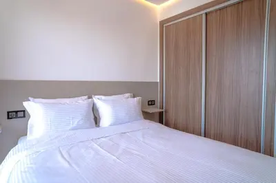 a bedroom with a large white bed with white pillows at Appartement luxueux &chaleureux Agdal rabat in Rabat