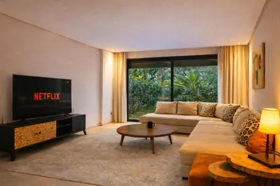 a living room with a couch and a tv at Ain Diab , Luxury El amri in Casablanca