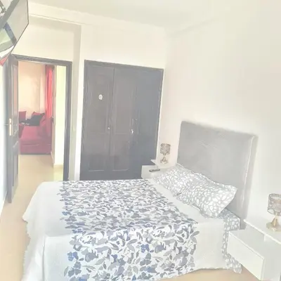 a bedroom with a bed with a blue and white comforter at Private Room in Shared Apartment step by mosquée Hassan II in Casablanca