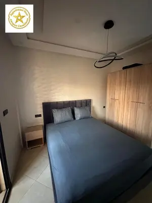 a bedroom with a bed with a blue bedspread at Appartement noor aéroport casablanca in Deroua