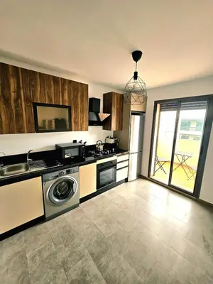 a kitchen with a stove and a dishwasher at Appartement De Standing - Face à La Plage -piscine in Mohammedia