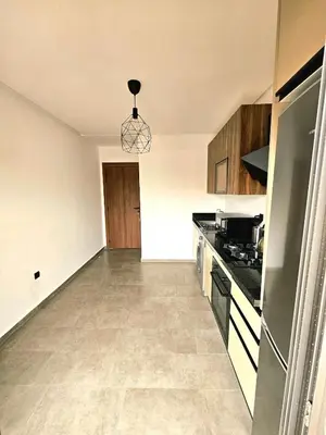 an empty kitchen with a stove and a refrigerator at Appartement De Standing - Face à La Plage -piscine in Mohammedia
