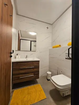 a bathroom with a white toilet and a sink at Appartement De Standing - Face à La Plage -piscine in Mohammedia