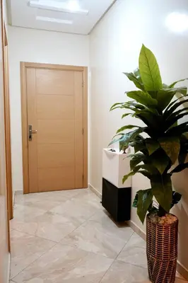 a hallway with a potted plant and a door at appartement with piscine & jardins - Détente à Bouznika, Rabat in Bouznika