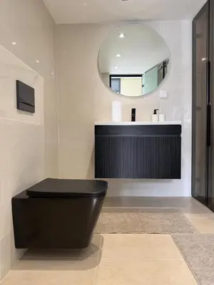 a bathroom with a black toilet and a mirror at Villa 1 prestige with Pool & Private Guests Suites in Sidi Yahia az Zaʼer