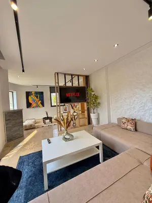 a living room with a couch and a table at Villa 1 prestige with Pool & Private Guests Suites in Sidi Yahia az Zaʼer
