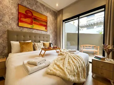 a bedroom with a large bed with a table on it at Maya Suites - Premium Stay - Racine in Casablanca