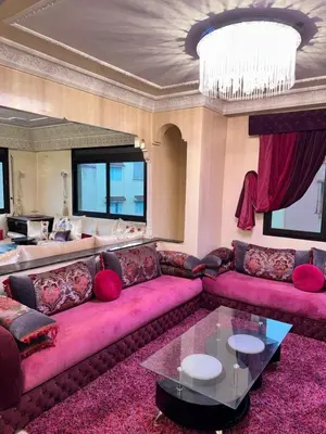a living room with a pink couch and a chandelier at Ideal appartement CAN2025 Grand Stade Rabat in Temara
