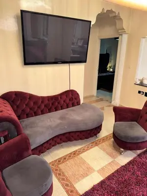 a living room with a red couch and a flat screen tv at Ideal appartement CAN2025 Grand Stade Rabat in Temara