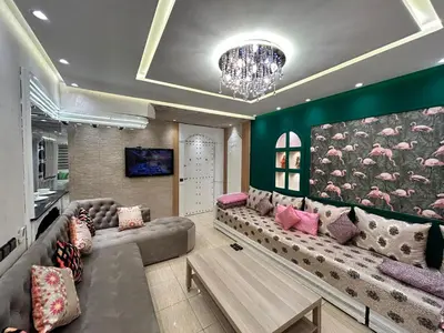 a living room with a large couch and a chandelier at Sympa appartement corniche in Casablanca