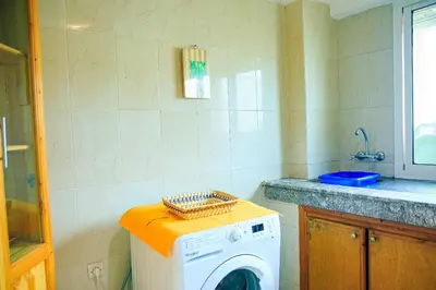 a washing machine in a kitchen with a counter at CAN Comfort 2 Bedrooms in Temara