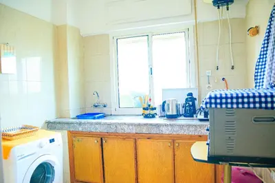a kitchen with a washing machine and a window at CAN Comfort 2 Bedrooms in Temara