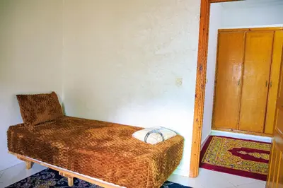 a bedroom with a bed and a chair in it at CAN Comfort 2 Bedrooms in Temara