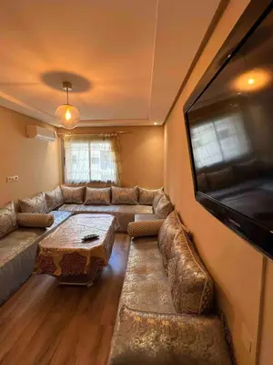 a living room with a couch and a flat screen tv at Appartment Maarif proche toutes commoditées in Casablanca