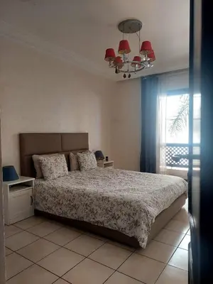 a bedroom with a bed and a window and a chandelier at Appartement Familial Casablanca in Casablanca