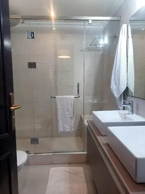 a bathroom with a glass shower and a sink at Appartement Familial Casablanca in Casablanca