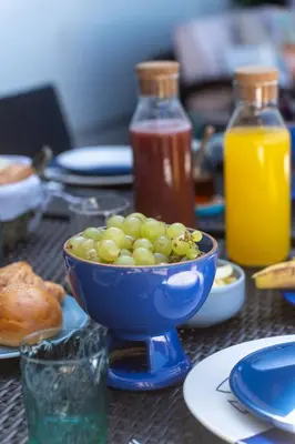 a blue bowl filled with green grapes on a table at Skhirat Oceanfront Villa 5 Bedrooms Direct Beach Access in Skhirat