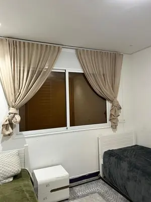 a bedroom with a bed and a large window at App 8 in Rabat