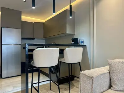 a kitchen with a bar with white stools in it at Luxurious & Central Princesses in Casablanca