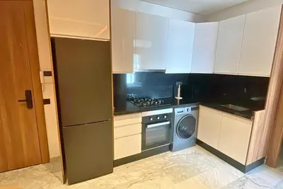 a kitchen with white cabinets and a washer and dryer at Quiet haven near Sheikh Khalifa Hospital in Casablanca