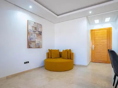 a yellow couch in a white room with a wooden door at Casa Contemporary 3 Beds - By AppartAli in Casablanca