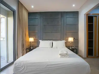 a bedroom with a large white bed with two lamps at Casablanca Breeze - By AppartAli in Casablanca