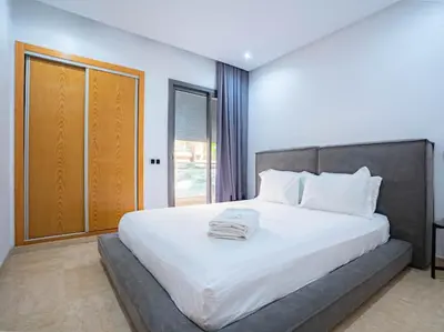 a bedroom with a large white bed with a window at Casablanca Breeze - By AppartAli in Casablanca