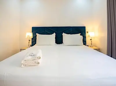 a white bed with a blue headboard and two lamps at Casablanca Breeze - By AppartAli in Casablanca