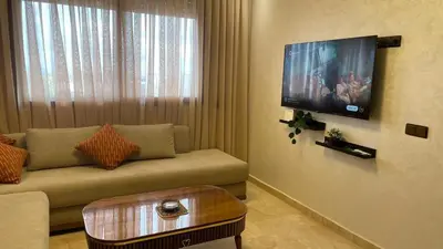 a living room with a couch and a flat screen tv at Studio moderne avec parking ascenseur -Maarif Centre in Aïn Sebaa