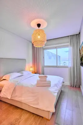a bedroom with a large white bed and a window at Oceanfront 2BR by Hassan II Mosque in Casablanca