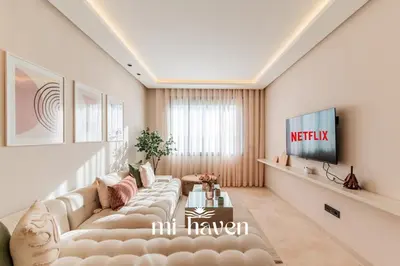 a living room with a couch and a tv at Aura - 1 BR - Premium Apartment in Maarif